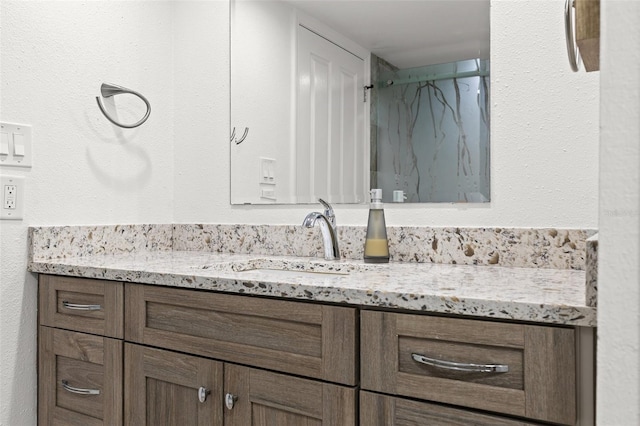 bathroom featuring walk in shower and vanity