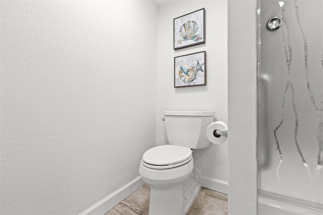 bathroom with baseboards and toilet