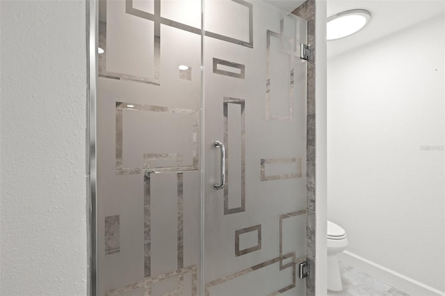 full bathroom featuring marble finish floor, a stall shower, toilet, and baseboards