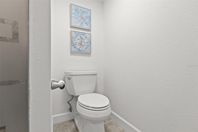 bathroom featuring toilet and baseboards