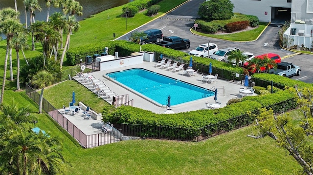 pool with a water view, a patio, and fence