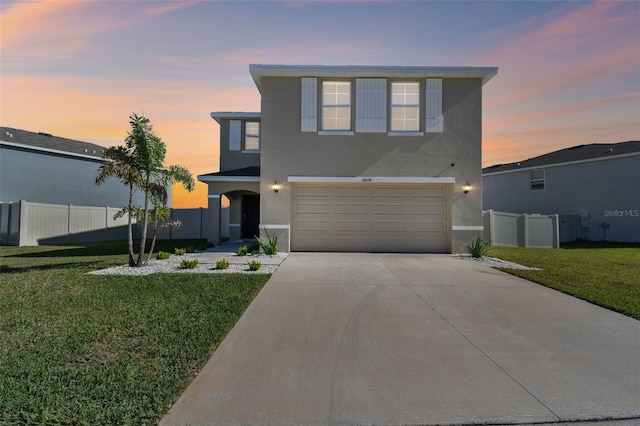 view of front facade featuring stucco siding, a garage, concrete driveway, and fence