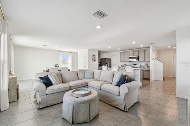 living room featuring light tile patterned floors, recessed lighting, visible vents, and baseboards