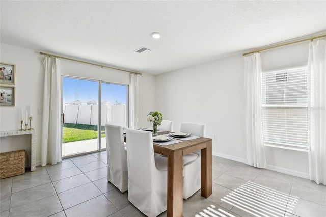 dining space with light tile patterned flooring, baseboards, and visible vents