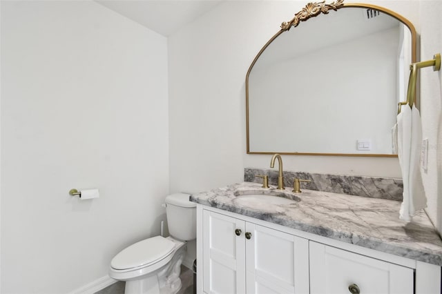 bathroom featuring baseboards, toilet, and vanity