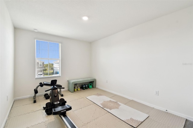 exercise area featuring carpet and baseboards