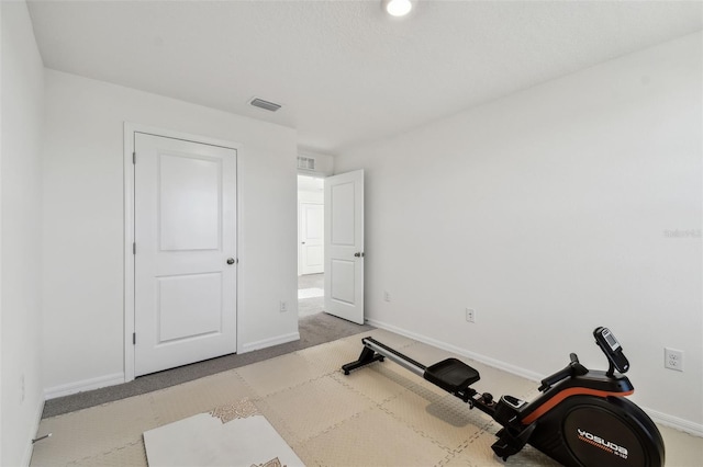 exercise room featuring light colored carpet, visible vents, and baseboards