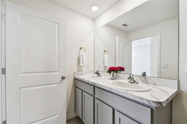 full bathroom featuring a sink, visible vents, and double vanity