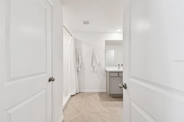 bathroom featuring tile patterned flooring, a shower with shower curtain, vanity, and baseboards