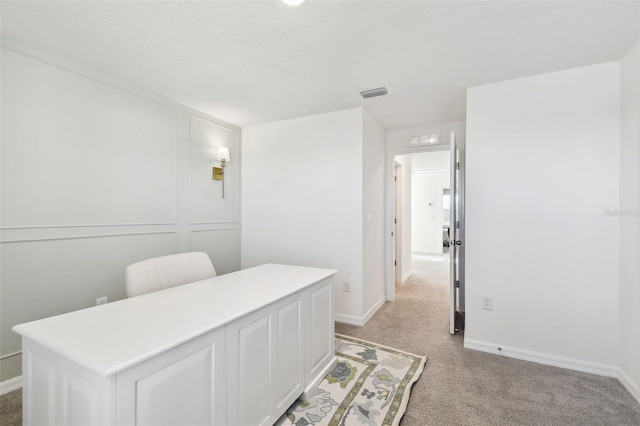 office area featuring visible vents, light colored carpet, and baseboards