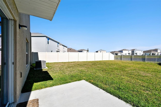 view of yard with a residential view, a patio, central AC, and a fenced backyard