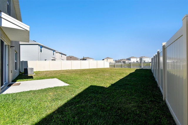 view of yard featuring a residential view, central AC unit, a patio, and a fenced backyard