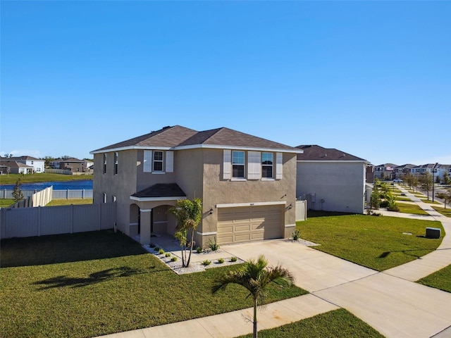 traditional-style house with a front lawn, fence, concrete driveway, stucco siding, and a garage