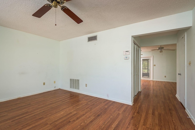 empty room featuring visible vents, a textured ceiling, and wood finished floors