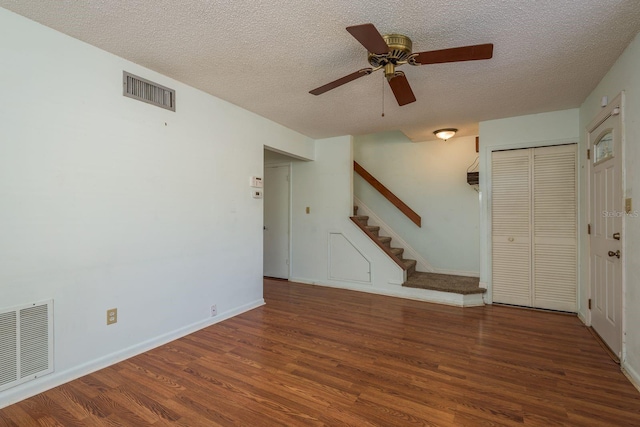 foyer entrance with visible vents, wood finished floors, and stairway