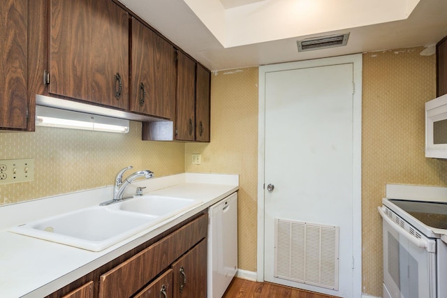 kitchen featuring visible vents, white appliances, wallpapered walls, and a sink