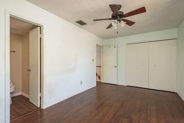 unfurnished bedroom featuring visible vents, a textured ceiling, wood finished floors, a closet, and baseboards