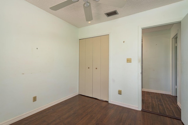 unfurnished bedroom featuring visible vents, a textured ceiling, wood finished floors, a closet, and baseboards