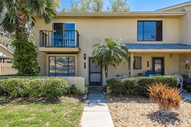 view of front of house featuring stucco siding and a balcony