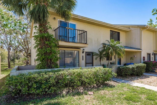 view of front of property featuring stucco siding and a balcony