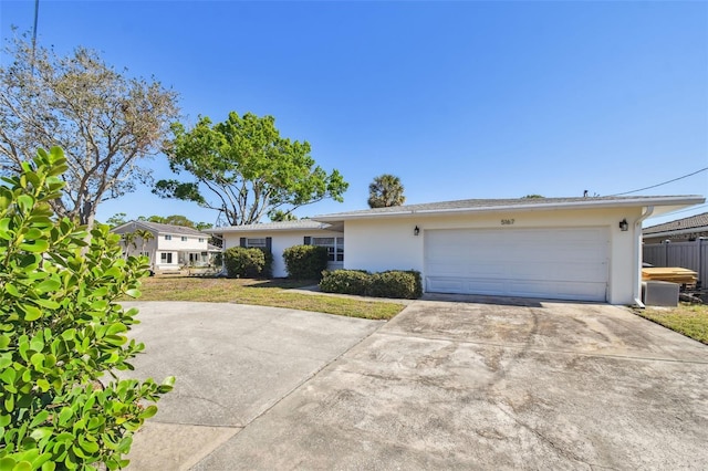 single story home with stucco siding, driveway, fence, a front yard, and a garage