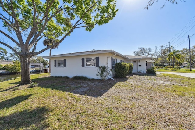 view of front of home featuring stucco siding and a front lawn