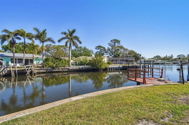 view of dock with a yard and a water view