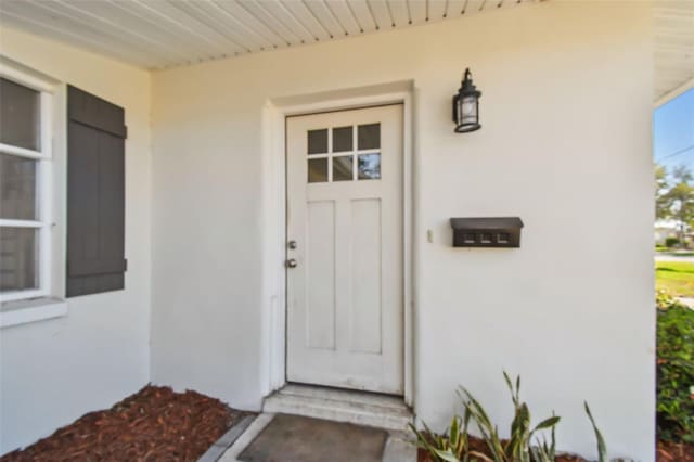 doorway to property featuring stucco siding