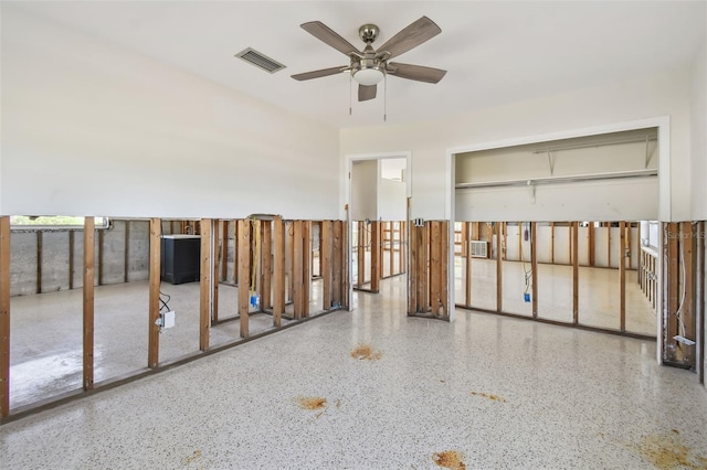 misc room featuring speckled floor, visible vents, and ceiling fan