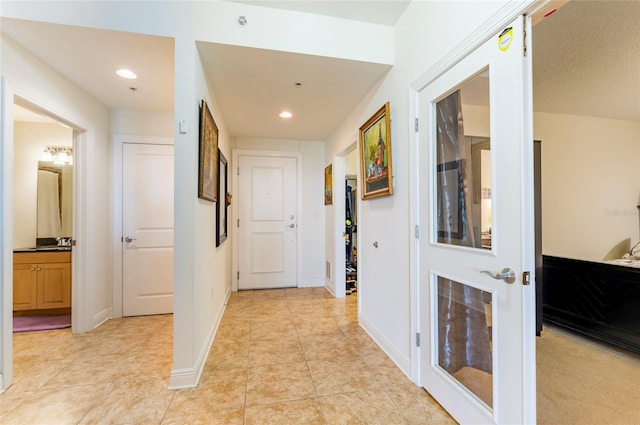 hallway with recessed lighting, baseboards, and light tile patterned flooring