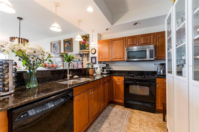 kitchen with light tile patterned floors, dark stone counters, a sink, black appliances, and brown cabinets