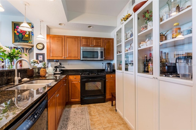 kitchen featuring stainless steel microwave, dishwasher, brown cabinets, black electric range, and a sink