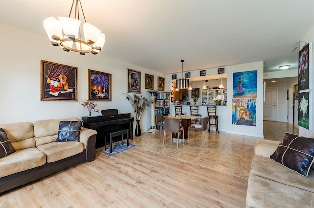 living room featuring a notable chandelier and light wood-type flooring