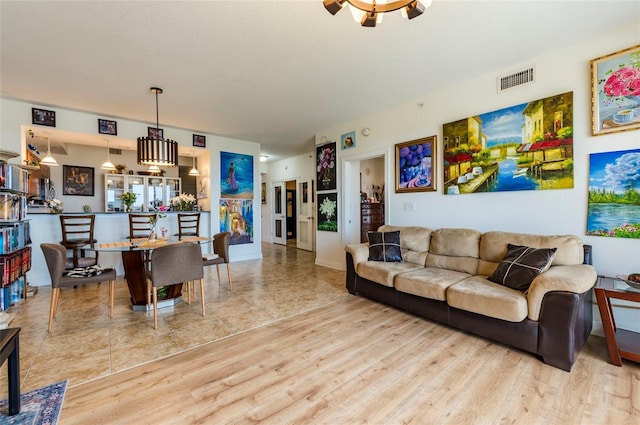 living area with ceiling fan, visible vents, and wood finished floors