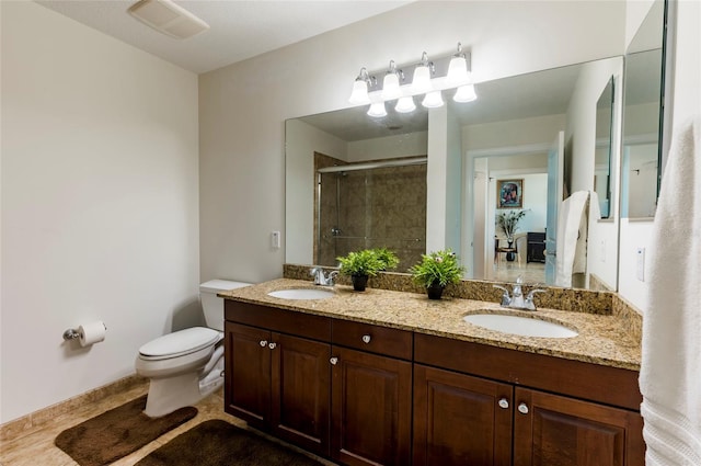 full bath featuring a sink, toilet, a stall shower, and double vanity