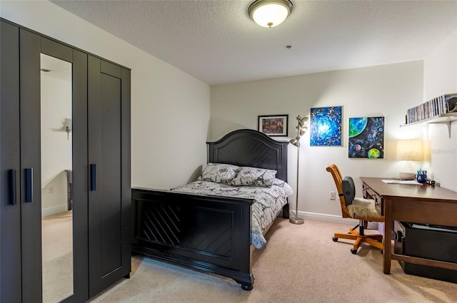 bedroom featuring light colored carpet, baseboards, and a textured ceiling