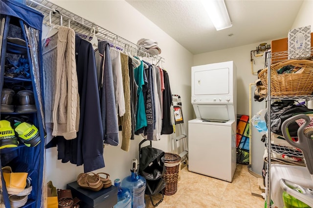 laundry area with light tile patterned floors, laundry area, and stacked washing maching and dryer