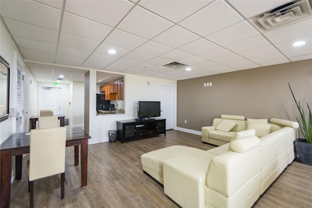 living room featuring visible vents, baseboards, and wood finished floors