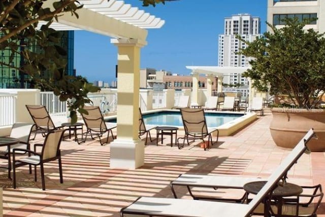 pool with a view of city, a patio area, and a pergola