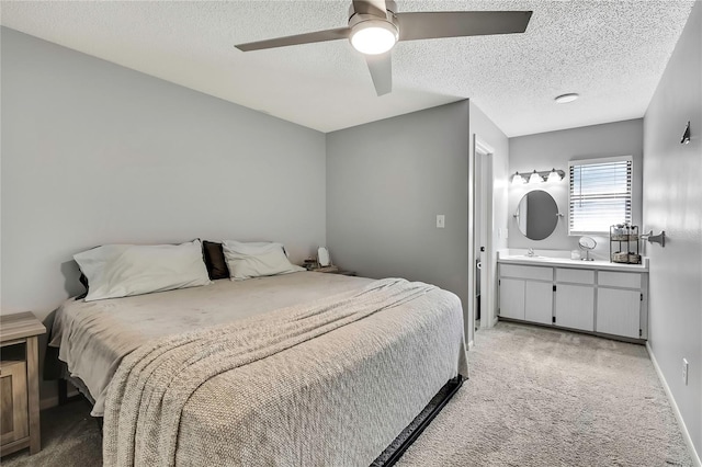 bedroom with light carpet, a textured ceiling, a ceiling fan, and a sink