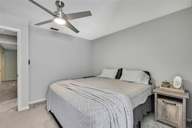 bedroom featuring visible vents, baseboards, light colored carpet, attic access, and ceiling fan