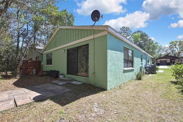 back of property featuring central air condition unit and fence