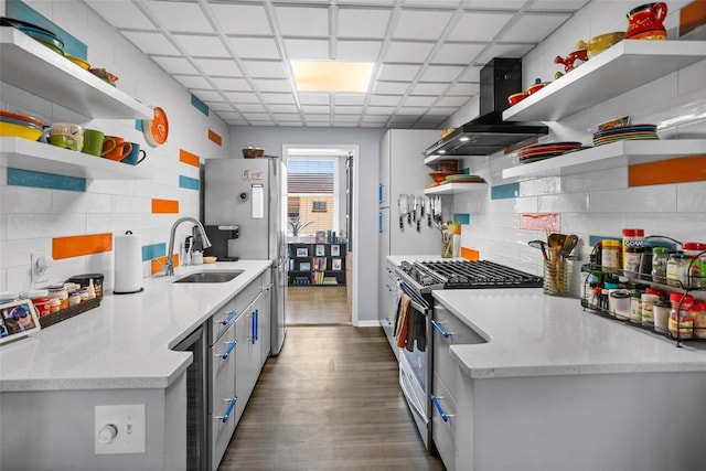 kitchen with open shelves, a sink, stainless steel appliances, decorative backsplash, and dark wood-style flooring