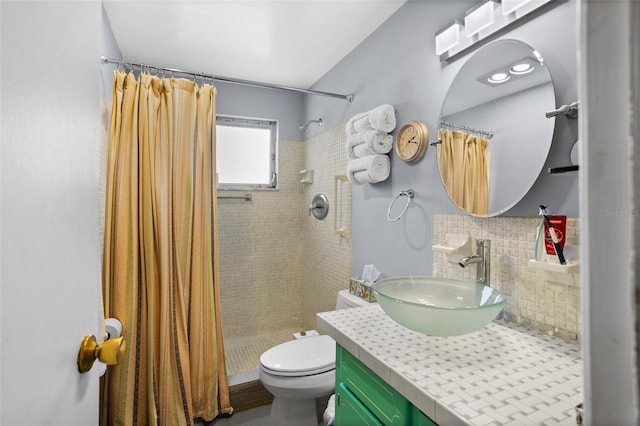 full bathroom featuring vanity, toilet, tasteful backsplash, and a tile shower