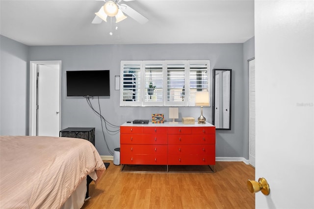 bedroom featuring ceiling fan, light wood-type flooring, and baseboards