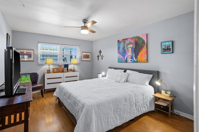 bedroom featuring wood finished floors, baseboards, and ceiling fan