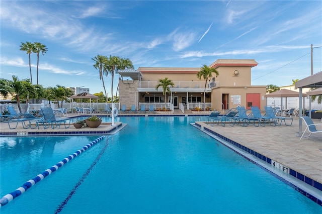 community pool with a patio and fence