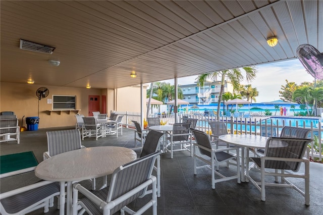 view of patio / terrace with outdoor dining area, fence, and a community pool