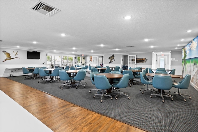 interior space featuring recessed lighting, visible vents, a textured ceiling, and wood finished floors