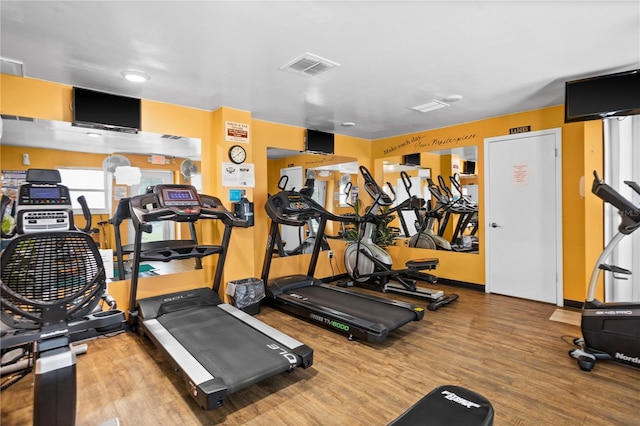 exercise room with wood finished floors and visible vents